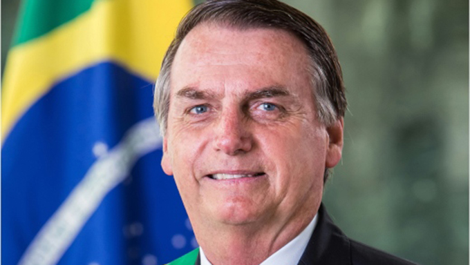   Bolsonaro posou com a faixa presidencial e a bandeira como cenário de fundo