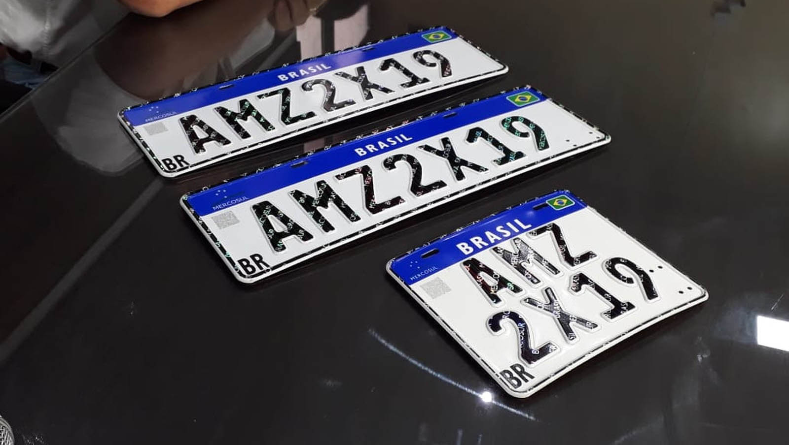   No versão divulgada nesta sexta a placa não terá mais lacre; não há mais as ondas sinuosas que cortavam os caracteres e a palavra "Mercosul" estampada nos caracteres deixa de ter acabamento brilhante.