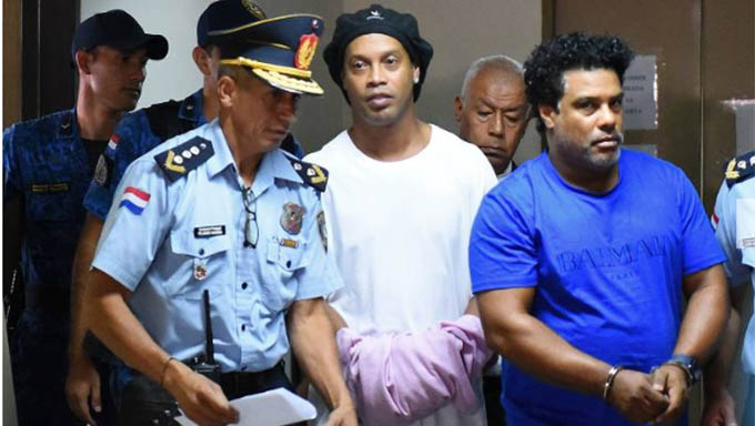   O ex jogador Ronaldinho Gaucho e o irmão Assis chegando para prestar depoimento a Justiça do Paraguai