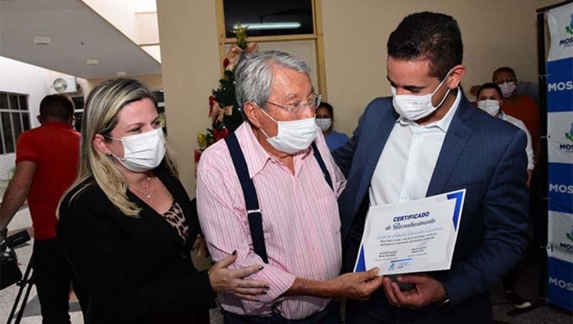 Imagem 1 - Além de Edgarde Benavides Carrasco, de 87 anos, sendo que 21 deles a serviço dos mossoroenses, foi um dos 14 homenageados pela gestão do prefeito Allyson Bezerra. Na ocasião, o gestor assinou o decretou para pagar todas as progressões dos mais de 1.700 servidores da saúde, num desembolso anual de R$ 2,7 milhões. "É a forma que o município encontrou para agradecer o trabalho desenvolvido pelos profissionais da Saúde na luta incansável contra a pandemia da Covid-19 em nossa cidade”, acrescentou Allyson. Imagem 1 - Além de Edgarde Benavides Carrasco, de 87 anos, sendo que 21 deles a serviço dos mossoroenses, foi um dos 14 homenageados pela gestão do prefeito Allyson Bezerra. Na ocasião, o gestor assinou o decretou para pagar todas as progressões dos mais de 1.700 servidores da saúde, num desembolso anual de R$ 2,7 milhões. "É a forma que o município encontrou para agradecer o trabalho desenvolvido pelos profissionais da Saúde na luta incansável contra a pandemia da Covid-19 em nossa cidade”, acrescentou Allyson.