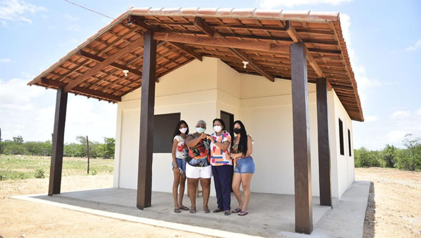 Imagem 1 - Governo do RN entrega primeiras casas e lotes de terra da Agrovila Jucurutu. A entrega feita aos moradores de Carnaúba Torta, dá início à relocação de famílias que vivem em áreas inundáveis da Barragem Oiticica, principal obra hídrica do Rio Grande do Norte, que o governo do Estado está construindo na Bacia do Piranhas/Açu. Nesta sexta-feira (18) foram entregues dezesseis das 37 casas e lotes de terra da Agrovila. A transferência representa o começo de uma nova vida para 56 pessoas, garantindo condições dignas de moradia, com acesso aos serviços de água tratada, energia elétrica, terra para o plantio e segurança alimentar dos trabalhadores. Imagem 1 - Governo do RN entrega primeiras casas e lotes de terra da Agrovila Jucurutu. A entrega feita aos moradores de Carnaúba Torta, dá início à relocação de famílias que vivem em áreas inundáveis da Barragem Oiticica, principal obra hídrica do Rio Grande do Norte, que o governo do Estado está construindo na Bacia do Piranhas/Açu. Nesta sexta-feira (18) foram entregues dezesseis das 37 casas e lotes de terra da Agrovila. A transferência representa o começo de uma nova vida para 56 pessoas, garantindo condições dignas de moradia, com acesso aos serviços de água tratada, energia elétrica, terra para o plantio e segurança alimentar dos trabalhadores.