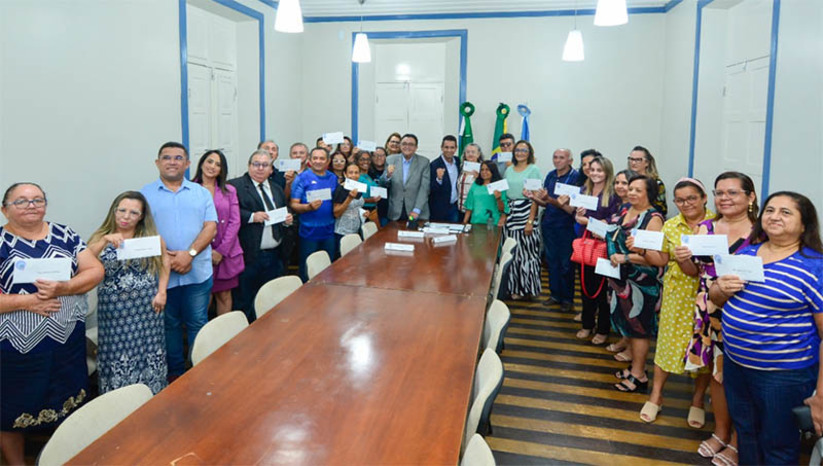 Imagem 1 -  PMM entrega portarias de aposentadorias e pensões a cerca de 40 servidores do município. A solenidade de entrega dos documentos, concedidos por meio do Instituto Municipal de Previdência Social dos Servidores de Mossoró (PREVI), foi realizada na tarde desta quinta-feira (10), no Salão dos Grandes Atos do Palácio da Resistência, sede da Prefeitura. “Foram 44 anos de dedicação à educação e especificamente no Município foram 30 anos. A gente hoje se sente feliz, agradecido a Deus, por ter vencido essa batalha tão grande. Durante todos esses anos sempre lutei por um ensino de qualidade. Por onde eu estive, e acho que dentro das limitações, eu cumpri o meu papel na educação de Mossoró e do Rio Grande do Norte”, disse o professor Honório Félix, celebrando a conquista de sua aposentadoria.