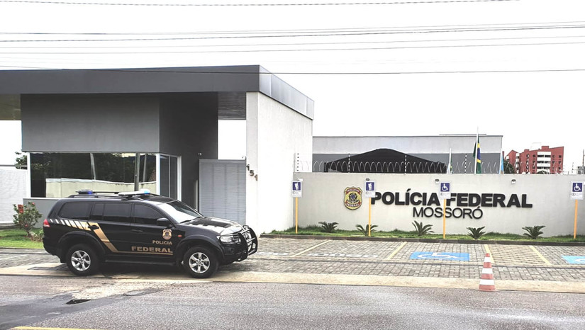 Imagem 1 -  Suspeito de repassar dinheiro falso em Mossoró é alvo de operação da Polícia Federal. A investigação, que culminou nesta quinta-feira (19) na Operação Fake Ballot, teve início no mês de agosto de 2021 quando um motorista de aplicativo procurou a Delegacia da Polícia Federal para relatar que um indivíduo teria efetuado o pagamento de uma viagem utilizando uma cédula falsa no valor de R$ 100. Desse modo, os elementos obtidos evidenciaram indícios da suposta prática do crime de moeda falsa, que prevê pena máxima de 12 anos de reclusão. Os policiais estão cumprindo um mandado de busca e apreensão expedido pela 10ª Vara da Justiça Federal/RN, em um endereço residencial no bairro Abolição IV.