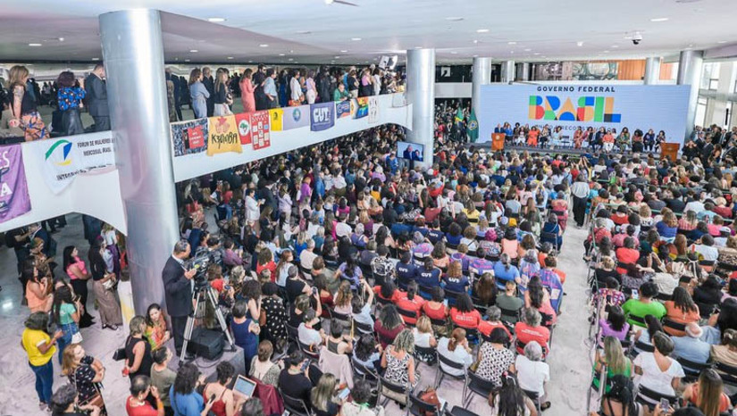 Imagem 1 - Presidente assina projeto que institui a igualdade salarial e remuneratória entre mulheres e homens. O documento foi assinado pelo presidente Luiz Inácio Lula da Silva em solenidade no Palácio do Planalto com mais de 900 pessoas para marcar o Dia Internacional das Mulheres. Além da igualdade salarial, o projeto de lei a ser encaminhado ao Congresso prevê aumento de multa nos casos de descumprimento da lei. Atualmente, o teto é de R$ 4 mil. A proposta é que passe a ser dez vezes o valor do maior salário pago na empresa. O texto indica ainda a previsão de indenização por danos morais à mulher quando for comprovado que ela recebe menos que o homem na mesma função e exige que a empresa apresente dados para garantir a fiscalização do cumprimento da obrigação de não pagar menos às mulheres. Imagem 1 - Presidente assina projeto que institui a igualdade salarial e remuneratória entre mulheres e homens. O documento foi assinado pelo presidente Luiz Inácio Lula da Silva em solenidade no Palácio do Planalto com mais de 900 pessoas para marcar o Dia Internacional das Mulheres. Além da igualdade salarial, o projeto de lei a ser encaminhado ao Congresso prevê aumento de multa nos casos de descumprimento da lei. Atualmente, o teto é de R$ 4 mil. A proposta é que passe a ser dez vezes o valor do maior salário pago na empresa. O texto indica ainda a previsão de indenização por danos morais à mulher quando for comprovado que ela recebe menos que o homem na mesma função e exige que a empresa apresente dados para garantir a fiscalização do cumprimento da obrigação de não pagar menos às mulheres.