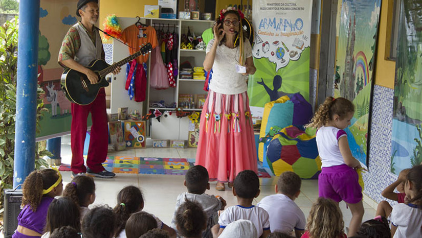 Imagem 1 - Projeto “Armarinho, Cantinho da Imaginação” realiza oficinas de artes cênicas para crianças de Baraúna. Ação aconteceu entre os dias 24 de abril e 03 de maio e aproximou crianças das artes cênicas. As seis escolas participantes do projeto receberam oficinas com o objetivo de aproximar as crianças da música, do teatro, da criação e da adaptação de sinopses e roteiros para aflorar a criatividade. Além das oficinas, as crianças tiveram acesso aos armarinhos, repletos de livros, brinquedos, jogos e cenários, e apresentações de teatro e fantoches. Em Baraúna, a ação contemplou 1550 crianças. Imagem 1 - Projeto “Armarinho, Cantinho da Imaginação” realiza oficinas de artes cênicas para crianças de Baraúna. Ação aconteceu entre os dias 24 de abril e 03 de maio e aproximou crianças das artes cênicas. As seis escolas participantes do projeto receberam oficinas com o objetivo de aproximar as crianças da música, do teatro, da criação e da adaptação de sinopses e roteiros para aflorar a criatividade. Além das oficinas, as crianças tiveram acesso aos armarinhos, repletos de livros, brinquedos, jogos e cenários, e apresentações de teatro e fantoches. Em Baraúna, a ação contemplou 1550 crianças.