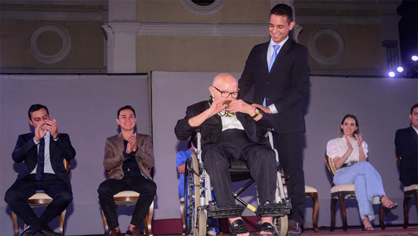 Imagem 1 -  “Eu me sinto forte, porque aí eu tenho certeza que tudo que eu fiz foi ao lado de alguém”. A frase é do Padre Sátiro Cavalcanti Dantas, o primeiro mossoroense a receber a medalha “Prefeito Rodolfo Fernandes”, a mais alta honraria da cidade. A homenagem aconteceu nesta terça-feira (13), data em que se celebrou os 96 anos da invasão do bando de Lampião ao município. “Esse era um reconhecimento que o Município estava devendo a Rodolfo Fernandes, o prefeito mais emblemático da história de Mossoró de todos os tempos. Essa medalha vai ser concedida a cada ano, a cada 13 de junho, a uma grande personalidade de Mossoró. E para receber a primeira medalha, de forma histórica, escolhemos o padre Sátiro, que tem um papel fundamental, ímpar, na história da Universidade do Estado do Rio Grande do Norte, na educação da cidade. Escolhemos alguém que representa muito bem a população de Mossoró, a educação e a fé do povo mossoroense”, disse Allyson Bezerra.