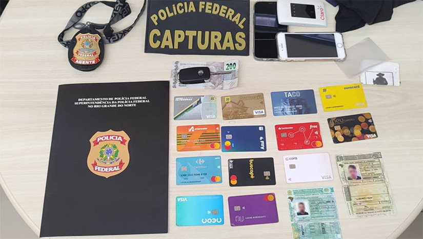 Imagem 1 -  Foragido da Justiça de Pernambuco é preso em condomínio no município de Natal. A prisão do homem de 38 anos, realizada pela Força-Tarefa de Capturas, integrada pela Polícia Federal e a Polícia Civil/RN, aconteceu nesta quarta-feira (6). A detenção se deu em cumprimento a um mandado de prisão expedido pela 2ª Vara da Comarca de Sertânia, TJPE. Os crimes dos quais o homem é acusado foram cometidos há cinco anos na zona rural de Sertânia, na Região do Sertão do Moxotó, ocasião em que uma carga roubada com 441 caixas de óleo refinado foi recuperada pela PM/PE. O acusado vivia na capital potiguar desde o ano de 2021 e atuava no ramo de comércio de veículos.