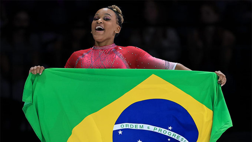 Imagem 1 - A Rainha da Ginástica Brasileira fez, neste sábado, algo que ninguém conseguiu até agora no Mundial de Ginástica Artística da Antuérpia, na Bélgica: desbancar o fenômeno do esporte, Simone Biles. Rebeca Andrade conseguiu o ouro no salto sobre a mesa ao obter a média 14.750. A norte-americana, que sofreu uma queda em um de seus saltos, o Biles 2, registrou 14.549. A sul-coreana Yeo Seojeong (14.416) completou o pódio. A ginasta de Guarulhos foi a última atleta a saltar. Na primeira rodada, executou um Cheng muito preciso, o que lhe valeu a nota 15.000. Depois, a brasileira mostrou um Yurchenko com dupla pirueta, que recebeu 14.500 pontos. Imagem 1 - A Rainha da Ginástica Brasileira fez, neste sábado, algo que ninguém conseguiu até agora no Mundial de Ginástica Artística da Antuérpia, na Bélgica: desbancar o fenômeno do esporte, Simone Biles. Rebeca Andrade conseguiu o ouro no salto sobre a mesa ao obter a média 14.750. A norte-americana, que sofreu uma queda em um de seus saltos, o Biles 2, registrou 14.549. A sul-coreana Yeo Seojeong (14.416) completou o pódio. A ginasta de Guarulhos foi a última atleta a saltar. Na primeira rodada, executou um Cheng muito preciso, o que lhe valeu a nota 15.000. Depois, a brasileira mostrou um Yurchenko com dupla pirueta, que recebeu 14.500 pontos.