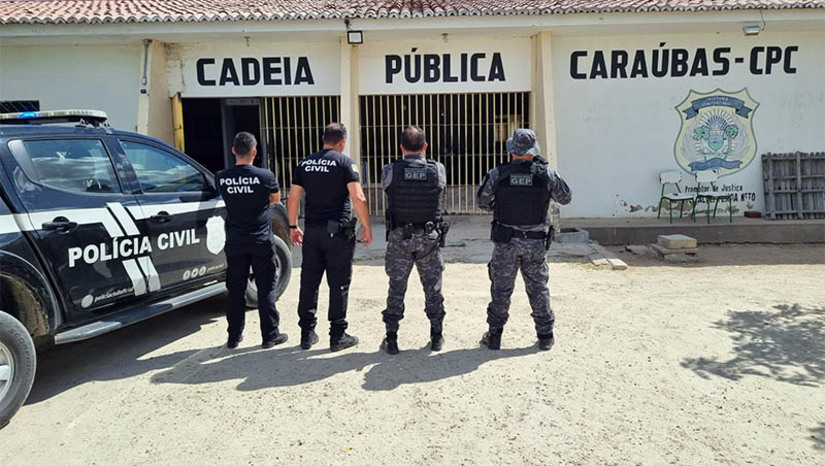 Imagem 1 -  PC prende integrantes de organização criminosa que planejava morte de diretor da cadeia pública de Caraúbas. A ação, realizada nesta quarta-feira (11), está inserida no âmbito da "Operação Paz". Ao todo, no decorrer das diligências, foram cumpridos seis mandados de prisão temporária e mandados de busca e apreensão. De acordo com as investigações, iniciadas a partir de relatórios de inteligência, os integrantes de uma organização criminosa – alguns presos e outros não – estariam insatisfeitos com o regime disciplinar da unidade prisional. Por isso, planejavam o homicídio do diretor. Algumas ordens eram repassadas por meio de familiares que realizavam visitas aos presos. O delegado de Caraúbas, Gabriel Napoli, que comandou as investigações, informou que as investigações continuam e outras diligências ainda serão realizadas. 