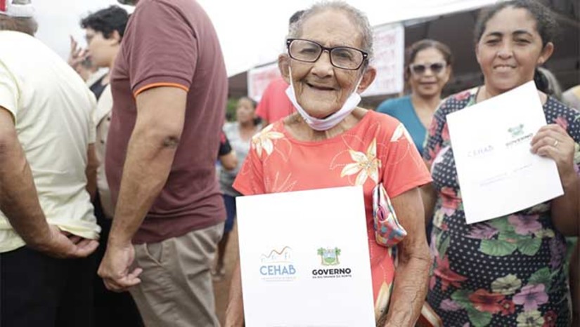 Imagem 1 -  Cerca de 159 famílias da Vila Industrial da Alcanorte, em Macau, distante 185 quilômetros da capital do Rio Grande do Norte, receberam nesta sexta-feira (14), os Termos de Cessão de Uso e Posse dos seus imóveis. A ação representa um marco histórico para aproximadamente de 640 pessoas. A iniciativa, que encerra uma luta de mais de quatro décadas, foi possível graças à intervenção do Governo do Estado. Em 2019, foi formado um grupo de trabalho para estudos socioeconômicos e jurídicos da comunidade.