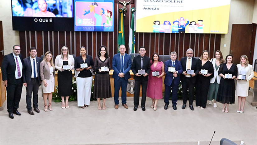 Imagem 1 - Proposta pelo deputado estadual Taveira Júnior (União), a Sessão Solene contou com a presença do parlamentar Luiz Eduardo (SDD), de representantes do Governo do Estado, Tribunal de Justiça do RN, Procuradoria Geral de Justiça, OAB/RN, além de outras autoridades e membros de instituições privadas ligadas à causa. “É com grande honra que me dirijo a todos vocês para falar sobre um tema de imensa importância: a adoção. Comemorada em 25 de maio, a data nos convida a refletir sobre o real significado desse gesto. A adoção é uma prática que vai muito além do ato legal, tocando profundamente as esferas da família, do amor e do ato de responsabilidade social; é um gesto de amor que transforma as vidas de inúmeras crianças e adolescentes”, destacou o propositor Taveira Júnior, no início do seu discurso. Imagem 1 - Proposta pelo deputado estadual Taveira Júnior (União), a Sessão Solene contou com a presença do parlamentar Luiz Eduardo (SDD), de representantes do Governo do Estado, Tribunal de Justiça do RN, Procuradoria Geral de Justiça, OAB/RN, além de outras autoridades e membros de instituições privadas ligadas à causa. “É com grande honra que me dirijo a todos vocês para falar sobre um tema de imensa importância: a adoção. Comemorada em 25 de maio, a data nos convida a refletir sobre o real significado desse gesto. A adoção é uma prática que vai muito além do ato legal, tocando profundamente as esferas da família, do amor e do ato de responsabilidade social; é um gesto de amor que transforma as vidas de inúmeras crianças e adolescentes”, destacou o propositor Taveira Júnior, no início do seu discurso.
