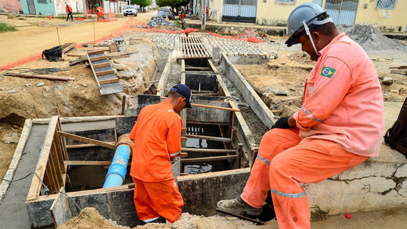 Imagem 1 -  Moradores comemoram drenagem no bairro Aeroporto; obras estão em fase de conclusão. Na rua Deoclécio Florêncio Freire está sendo finalizada a segunda grelha de captação, com a tampa que irá proteger as tubulações de abastecimento de água da Companhia de Águas e Esgotos do Rio Grande do Norte (Caern). O projeto conta 224 metros de manilhas de concreto de 800 mm; 20 m de manilhas de concreto de 400 mm; 23 m de grelhas com 1,35 m de largura cada, totalizando 31 m² de captação de águas pluviais.