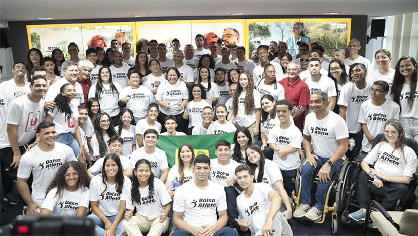 Imagem 1 -  RN paga primeira parcela do “Bolsa Atleta Potiguar” para 90 credenciados. O programa tem como objetivo apoiar e incentivar atletas de alto rendimento do Rio Grande do Norte, proporcionando suporte financeiro para os treinamentos e competições. O programa foi efetivado nesta segunda-feira (12), durante solenidade realizada em Natal. “Pela primeira vez o Bolsa Atleta é instituído com orçamento definido no RN. Estamos investindo R$ 700 mil, com a primeira parcela para hoje e mais 11, uma a cada mês. Nosso Governo reconhece o esporte como uma importante ferramenta de justiça social. O programa é um compromisso com nossos atletas, dando suporte financeiro para desenvolver o talento”, afirmou a governadora Fátima Bezerra.