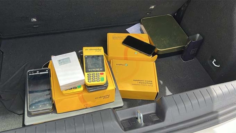 Imagem 1 -  A ação teve como objetivo o cumprimento de dois mandados de busca e apreensão contra dois homens, de 30 e 27 anos, suspeitos de praticar fraudes eletrônicas em desfavor de uma instituição financeira. Os mandados foram executados nos municípios de Pau dos Ferros e São Miguel do Oeste.   As investigações apontam que os suspeitos utilizavam cartões de crédito clonados para realizar compras simuladas em maquinetas de cartão que estavam em sua posse. Em seguida, os valores eram transferidos para contas vinculadas às maquinetas e, posteriormente, os investigados contestavam as transações junto à operadora do cartão, resultando em prejuízo para a instituição financeira vítima.