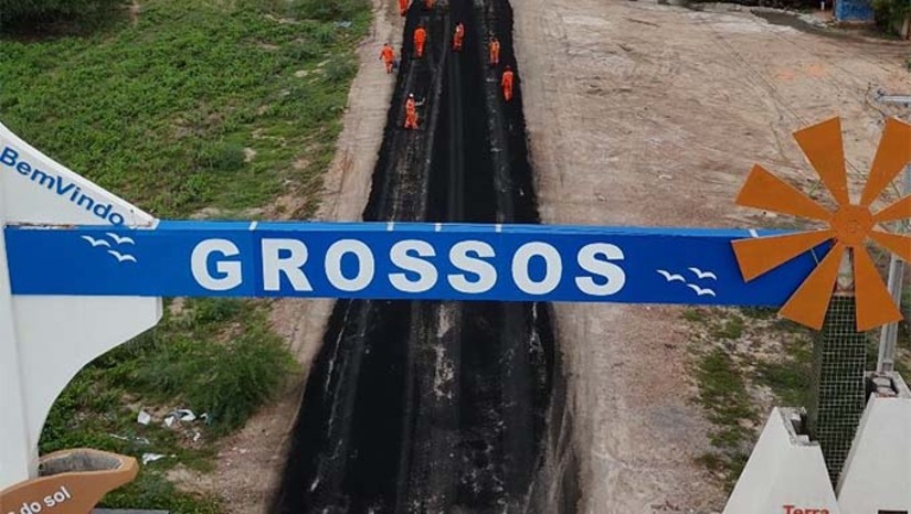 Imagem 1 -  Embora a recuperação da RN 012 seja de responsabilidade do Departamento de Estradas de Rodagem do Rio Grande do Norte (DER), a Prefeitura de Grossos incluiu o serviço no programa Acelera Grossos. A iniciativa já contemplou o recapeamento completo da Avenida Raimundo Gonçalves, principal via da cidade. A restauração do trecho inicial da RN 012 está em ritmo acelerado, com previsão de conclusão nos próximos dias. A obra em questão se estende por toda a Avenida Raimundo Gonçalves, resultando na recuperação asfáltica de 3,8 km de extensão.