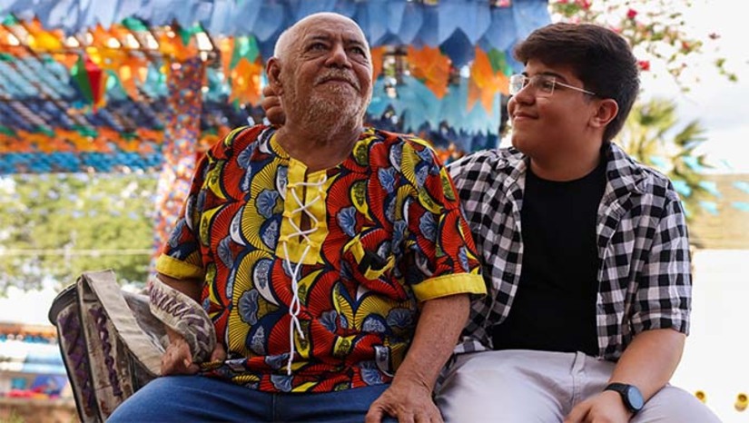 Imagem 1 -  Desde sua criação no Mossoró Cidade Junina, o Polo Poeta Antônio Francisco se tornou um sucesso, reunindo grande público e homenageando o poeta mossoroense em vida. O espaço valoriza a cultura nordestina com poesia, música, humor e artistas locais, regionais e nacionais. Antônio Francisco compartilha o palco com o neto Segundo, que segue seus passos na poesia e cordel. O poeta destaca a importância da humildade como conselho ao neto e celebra o reconhecimento recebido da população e visitantes.