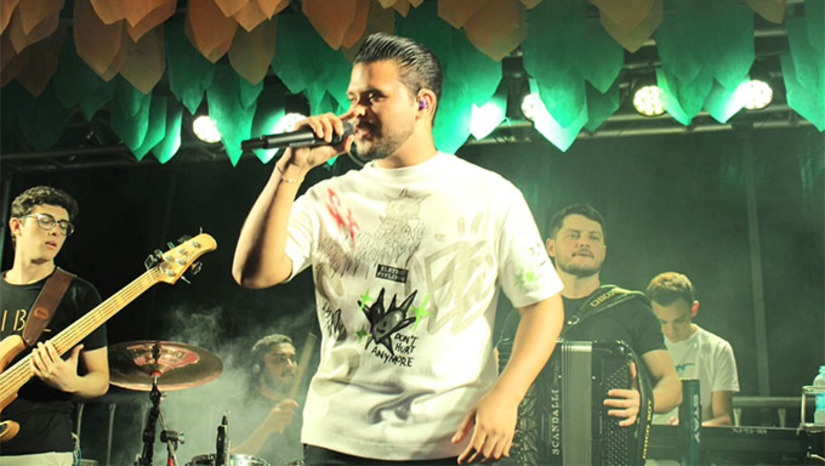 Imagem 1 - A abertura ficou por conta de Cauanzinho Cantor, natural de Pau dos Ferros-RN, que fez sua estreia no Mossoró Cidade Junina. Visivelmente emocionado, o artista realizou um sonho de cantar para o público mossoroense, trazendo um repertório animado e romântico, que mesclou forró pé de serra, forró romântico e música sertaneja. “É uma emoção muito grande. É minha primeira vez aqui. Espero ser a primeira de muitas. Cantar aqui é a realização de um sonho. Mossoró é referência cultural e estar no Cidade Junina é uma conquista”, afirmou Cauanzinho após a apresentação. Imagem 1 - A abertura ficou por conta de Cauanzinho Cantor, natural de Pau dos Ferros-RN, que fez sua estreia no Mossoró Cidade Junina. Visivelmente emocionado, o artista realizou um sonho de cantar para o público mossoroense, trazendo um repertório animado e romântico, que mesclou forró pé de serra, forró romântico e música sertaneja. “É uma emoção muito grande. É minha primeira vez aqui. Espero ser a primeira de muitas. Cantar aqui é a realização de um sonho. Mossoró é referência cultural e estar no Cidade Junina é uma conquista”, afirmou Cauanzinho após a apresentação.