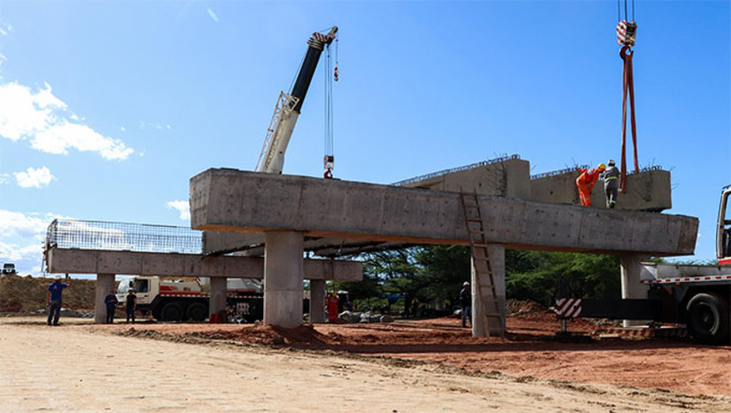 Imagem 1 -   Nesta etapa, as frentes de trabalho concentram-se na implantação da ponte que cruza o Rio Mossoró, estrutura projetada superior a 140 metros. Após o içamento das 42 longarinas, será iniciada a instalação das lajes pré-moldadas, já concretadas. Em seguida, será executada a concretagem de acabamento, a aplicação da capa asfáltica sobre a ponte e, na etapa final, a sinalização da via e liberação do tráfego para circulação de veículos. Toda a obra contará ainda com iluminação inteiramentem em LED.