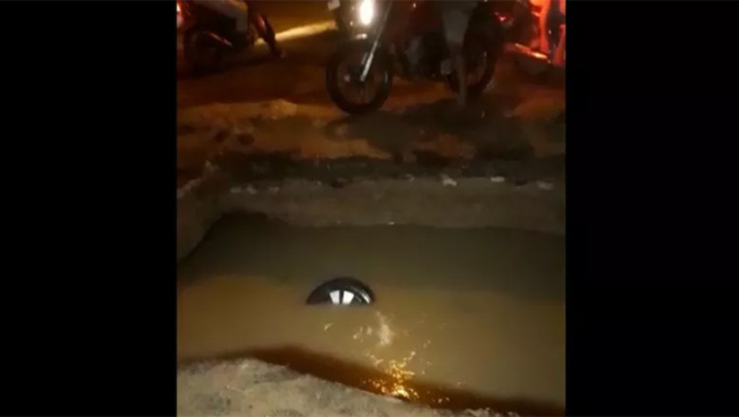 Imagem 1 -  Cada cidadão deve ser indenizado em R$ 8 mil por ter caído (estavam se deslocando num carro de um deles) num buraco que a CAERN fez, em maio de 2020, na Avenida Alberto Maranhão, em Mossoró-RN, para consertar o coletor tronco do sistema de esgotos e quase morreram afogados, sendo que uma das vítimas precisou passar por lavagem estomacal. O veículo ficou só com parte de um das rodas à vista. A Justiça entendeu que não havia sinalização adequada no local.