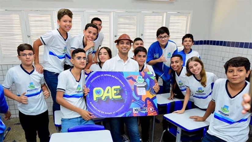 Imagem 1 - O Programa de Apoio ao Estudante (PAE), criado em 2025 pelo prefeito de Mossoró, Allyson Bezerra, oferece auxílio financeiro a alunos da rede municipal de famílias de baixa renda. O benefício é de R$ 200 por mês durante o período letivo e R$ 300 em janeiro e julho, para estudantes que estejam matriculados e cumpram critérios como vacinação em dia, boa frequência, notas e comportamento. O programa busca reduzir evasão e abandono escolar, além de incentivar o desempenho acadêmico e a inclusão social. Em 2026, foi aberto um segundo edital com mais 5 mil vagas, já com cerca de 5.400 inscritos, e as inscrições seguem até 8 de março pelo site da prefeitura. Imagem 1 - O Programa de Apoio ao Estudante (PAE), criado em 2025 pelo prefeito de Mossoró, Allyson Bezerra, oferece auxílio financeiro a alunos da rede municipal de famílias de baixa renda. O benefício é de R$ 200 por mês durante o período letivo e R$ 300 em janeiro e julho, para estudantes que estejam matriculados e cumpram critérios como vacinação em dia, boa frequência, notas e comportamento. O programa busca reduzir evasão e abandono escolar, além de incentivar o desempenho acadêmico e a inclusão social. Em 2026, foi aberto um segundo edital com mais 5 mil vagas, já com cerca de 5.400 inscritos, e as inscrições seguem até 8 de março pelo site da prefeitura.